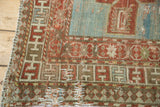 Storied antique Caucasian rug corner with geometric borders and decorative edge repair.