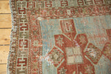 Geometric Laleh Abassi border on a distressed antique Caucasian rug with pale blue field.