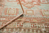 Distressed antique Caucasian rug showcasing geometric Laleh Abassi motif in powder blue and terra cotta.