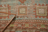 Detail of antique Caucasian rug featuring rectilinear pawn motifs in terra cotta, soft blue, and beige.