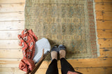 Distressed vintage Turkmen rug showing faded elephant footprint guls in soft rust and blue tones.