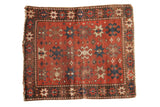 Antique Kazak rug with geometric crab and starburst design in brick red, navy, and beige.