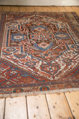 Fringed end of antique Afshar rug, revealing red, blue, brown geometric motifs and wear.