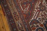 Intricate madder red, sky blue, beige floral and serrated patterns on an antique Afshar rug.