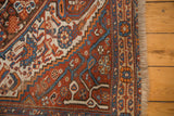 Secured fringe and intricate madder red, blue, and orange serrated floral motifs on antique Afshar.
