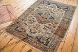Angled room view of a traditional antique Persian Tabriz rug with warm, storied patina.