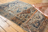 A decorative view of an antique Haji Jalili Tabriz rug's warm ivory, navy, and rust floral pattern.