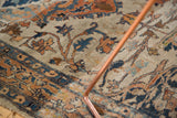 Scrolling vinery and floral arabesques in rust and navy on the low pile of an antique Tabriz rug.