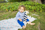 Blue and white striped organic cotton dog toy held by a toddler.