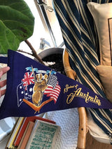 Vintage blue felt Australia banner with koala graphic, national flags, and golden script.