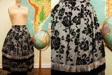 Vintage 50s skirt with black velvet rose motifs, pleated fabric, and light fringed trim.