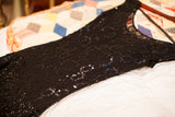 Shimmering black sequins with intricate lace detailing on a vintage 50s gown.