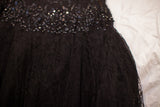 Intricate black lace skirt texture with shimmering sequin drop-waist on the vintage gown.