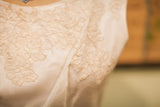 Close-up of the elegant floral lace on the cream vintage 60s wedding dress.