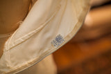 Vintage 60s wedding dress interior with creamy lining, ILGWU union label, and subtle fraying.