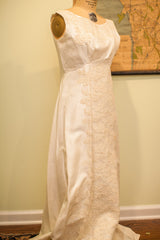 Vintage 60s wedding dress with flowing skirt and intricate side lace details.