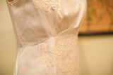Intricate lace detailing and textured fabric of the vintage 60s wedding dress.