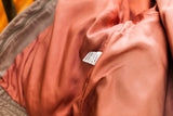 Lillie Rubin leather jacket's red-orange satin lining and 'GENUINE LEATHER' care tag.