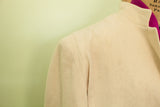 Ivory cashmere coat shoulder and collar with hint of magenta lining, revealing soft texture.