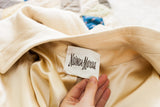 Vintage Neiman Marcus label on ivory cashmere coat, revealing luxurious silk lining.