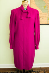 Fuchsia dress hem and tailored long sleeve cuff with matching buttons.