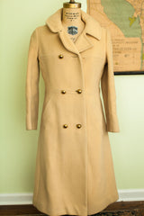 Buttery yellow vintage wool coat's lower front with gold buttons and pocket detail.