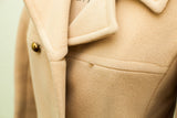 Buttery yellow Saks Fifth Avenue wool coat detail, showing gold button and small moth bite.
