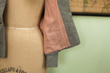 Vintage 40s gray wool jacket sleeve detail showing a loose button and pink lining.
