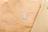 Peach lining and white union label inside a vintage yellow wool coat.