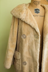Close-up of the coat's round lucite buttons and soft ivory sheared beaver fur.