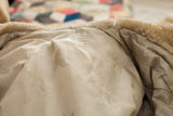 Vintage 60s fur coat's ivory lining, featuring embossed floral pattern and minor stains.