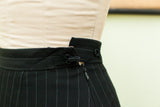 Vintage Gaultier black pinstripe skirt, close-up of herringbone waistband, zipper, and loop closures.
