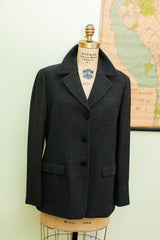 Dark herringbone fabric and tailored lapel of a vintage Giorgio Armani suit jacket.