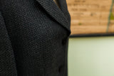 Giorgio Armani suit jacket's dark grey herringbone fabric texture with two visible buttons.