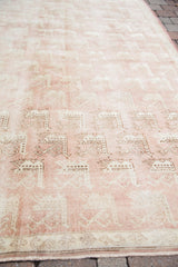 Repeating traditional bird motifs in beige on the light peach rose Oushak carpet.