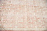 Repeating bird motifs on the light peach rose field of a vintage Turkish Oushak rug.