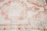 Faded coral red and ivory tones highlight the distressed pattern detail of the Oushak rug.