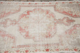 Distressed pile texture with faded red and ivory large simple motifs.