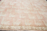 Repeating bird motif pattern and stylized border on the vintage peach rose Oushak carpet.