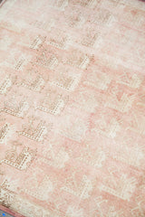 Faded repeating bird motifs on the light peach rose field of a vintage Oushak.