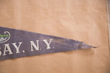 Frayed pointed tip of vintage blue felt flag displaying white 'BAY, N.Y.' text.