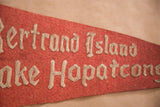 Aged red felt texture with raised off-white gothic lettering on vintage flag.