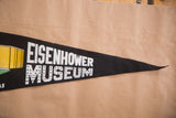 White block text with star pattern on the tapering black felt Eisenhower Museum flag.