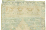 Vintage Oushak rug section with blanched ivory, seafoam green, and gold geometric pattern.