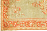 Corner detail: light green Oushak field with curvilinear design, brilliant rusty orange border.