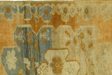 Heavy abrash across pumpkin rust, teal, and ivory stylized floral motifs on vintage Oushak rug.