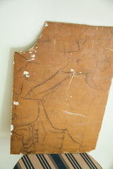 Reverse side of the 1940s painting showing a brown board with a cowboy sketch.