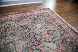 Distressed pile revealing foundation and floral motifs on an antique Kerman rug.