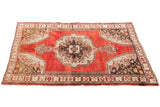 Vintage Oushak rug featuring a bold central medallion, rust red field, and charcoal bronze corner motifs. 4'5