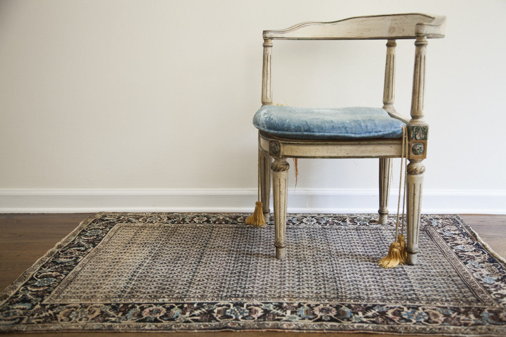Antique Persian Farahan rug with fine, repeating vertical stripes in gold, black, and blue tones.
